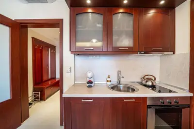 a kitchen with wooden cabinets and a sink at Ski Lift Delight Bansko Apartment in Bansko
