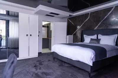 a bedroom with a large bed with a black marble headboard at A-Dent luxury apartments & Dental Clinic in Gotse Delchev