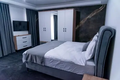 a bedroom with a bed and a dresser at A-Dent luxury apartments & Dental Clinic in Gotse Delchev