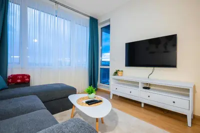 a living room with a couch and a tv at Bright and Cosy 1BD Flat - Perfect for Business Trip by Flat Mаnager in Sofia