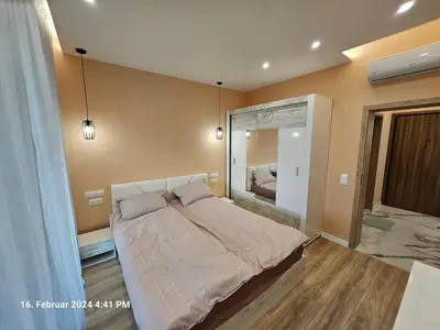 a bedroom with a large bed and a mirror at Dilyanka in Pernik