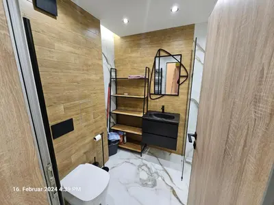 a bathroom with a sink and a mirror and a toilet at Dilyanka in Pernik