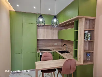 a kitchen with green cabinets and two pink chairs at Dilyanka in Pernik