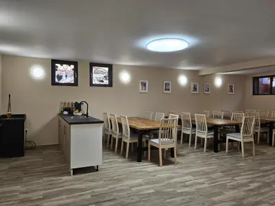 a dining room with tables and chairs and a counter at Villa Geronimo in Bansko