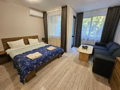 a bedroom with a bed and a blue couch at Borovets gardens Studio A12 in Borovets