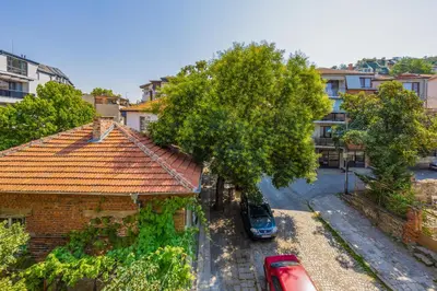 a car parked next to a house with a tree at Spacious Central Apt by Stefanie / close to MU in Plovdiv