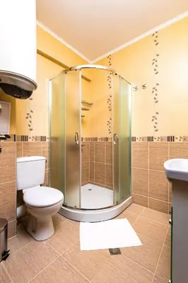 a bathroom with a toilet and a glass shower at Spacious Central Apt by Stefanie / close to MU in Plovdiv