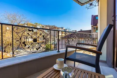 a balcony with a chair and a cup on a table at Spacious Central Apt by Stefanie / close to MU in Plovdiv