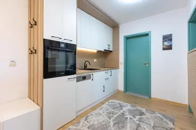 a kitchen with white cabinets and a blue door at Mountain Escape & View & Relax in Bansko