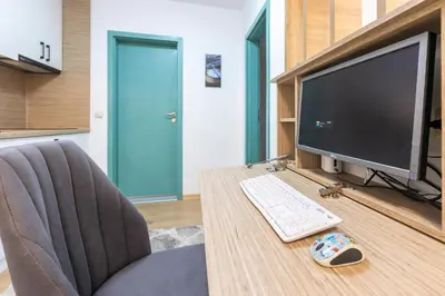 a desk with a computer monitor and a keyboard and mouse at Mountain Escape & View & Relax in Bansko