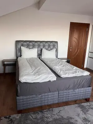 a bedroom with a large bed with a headboard at Двуспален апартамент в к-с Пирин Палас in Bansko