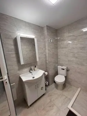 a bathroom with a sink and a toilet and a mirror at Двуспален апартамент в к-с Пирин Палас in Bansko