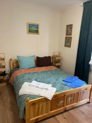 a bedroom with a wooden bed with blue pillows at NiDo Cozy 3BR Apartment Kapana Top Center in Plovdiv