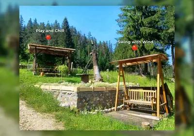 a park with a bench and a swing with wind at ВИЛА ПЕРИКА-Vila PERIKA in Borino