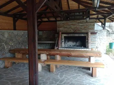 a picnic table and benches in front of a fireplace at 705 in The Stream Resort in Pamporovo
