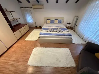 a bedroom with a bed and two rugs at The Maisonette in Sofia's Heart in Sofia