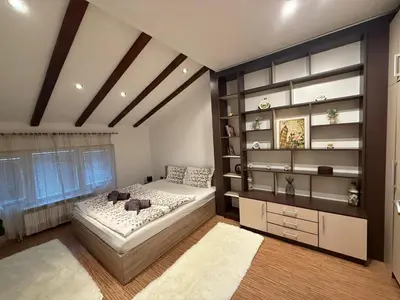 a bedroom with a bed and a book shelf at The Maisonette in Sofia's Heart in Sofia