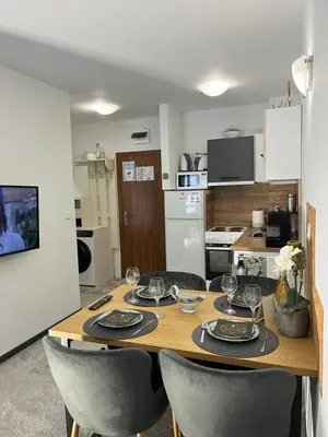 a dining room table with chairs and a kitchen at Elizi1winter apartments Pamporovo in Pamporovo