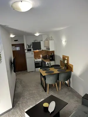 a living room with a table and a kitchen at Elizi1winter apartments Pamporovo in Pamporovo