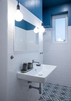 a white bathroom with a sink and a window at Bohemian Central Apartment Sofia in Sofia