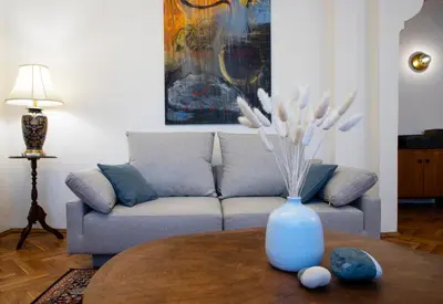 a living room with a couch and a vase on a table at Bohemian Central Apartment Sofia in Sofia