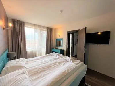 a large white bed in a room with a window at Private Villa in Ruskovets in Dobrinishte