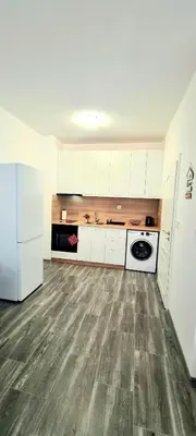 an empty kitchen with white cabinets and a refrigerator at Flower home 11 in Sofia
