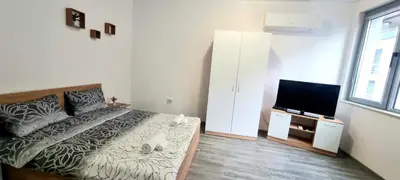 a bedroom with a bed and a flat screen tv at Flower home 11 in Sofia