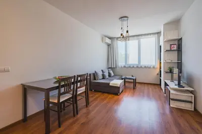 a living room with a table and a couch at Sunny 1BDR Apartment near Center in Sofia