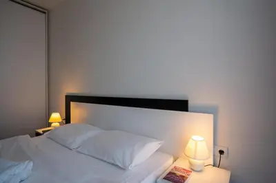a bedroom with a white bed with two lamps at Sunny 1BDR Apartment near Center in Sofia