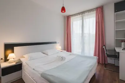 a bedroom with a large white bed and a window at Sunny 1BDR Apartment near Center in Sofia