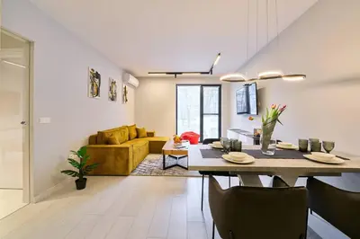 a dining room and living room with a table and a couch at Scandinavian Stay - Awarded Bldg - Downtown in Sofia