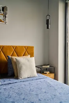 a bed with a blue comforter and a white pillow at Scandinavian Stay - Awarded Bldg - Downtown in Sofia