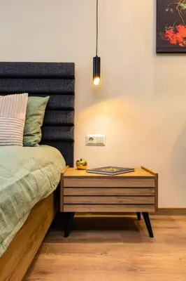 a bedroom with a bed with a wooden night stand at Green Hills Plovdiv close to Medical University in Plovdiv