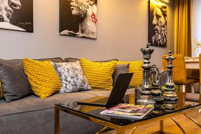 a living room with a couch with a laptop on a table at Apollo Apartment close to Medical University in Plovdiv