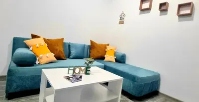 a blue couch with pillows and a table in a room at Flower home 10 in Sofia