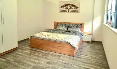 a bedroom with a bed with a wooden floor at Flower home 10 in Sofia