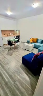 a living room with a blue couch and a table at Flower home 10 in Sofia