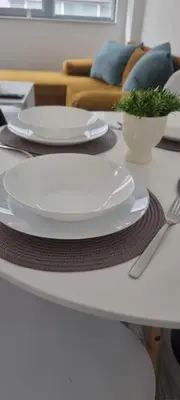 a table with white plates and a fork and knife at Flower home 10 in Sofia