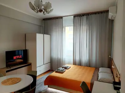 a bedroom with a bed and a tv and a table at Studio 72 in Sofia