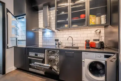 a kitchen with a washer and dryer in it at SOHO 13 - Black & White in Sofia