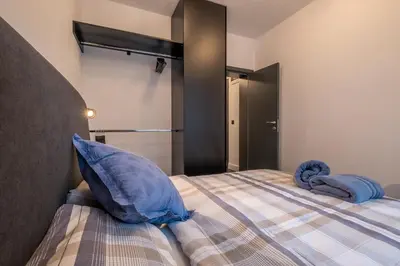 a bedroom with a bed with a blue pillow at SOHO 13 - Black & White in Sofia
