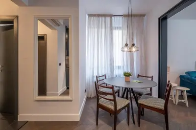 a living room with a table and chairs and a room at SOHO 13 - Black & White in Sofia