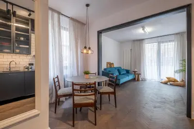 a living room with a table and a blue couch at SOHO 13 - Black & White in Sofia