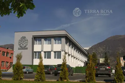 a building with cars parked in a parking lot at Хотел Терра Роза in Karlovo