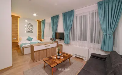 a living room with a bed and a couch at Хотел Терра Роза in Karlovo
