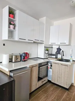 a kitchen with white cabinets and a counter top at Boutique Studio B37 in Borovets
