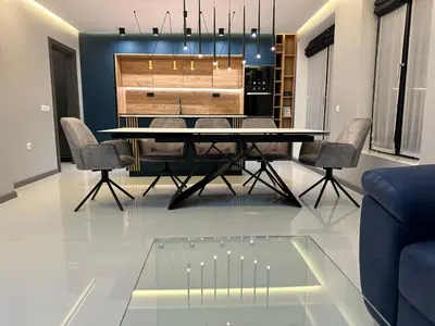 a dining room with a glass table and chairs at Regatta Park 2BR Exclusive Suite Parking Included in Plovdiv