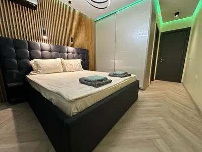 a bedroom with a large bed with a black headboard at Regatta Park 2BR Exclusive Suite Parking Included in Plovdiv