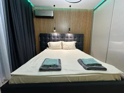 a bedroom with a bed with two towels on it at Regatta Park 2BR Exclusive Suite Parking Included in Plovdiv